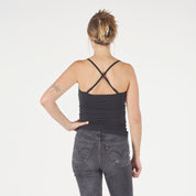 a woman wearing a Ridge Merino Wool Cami Tank Top in black with the back straps crossed