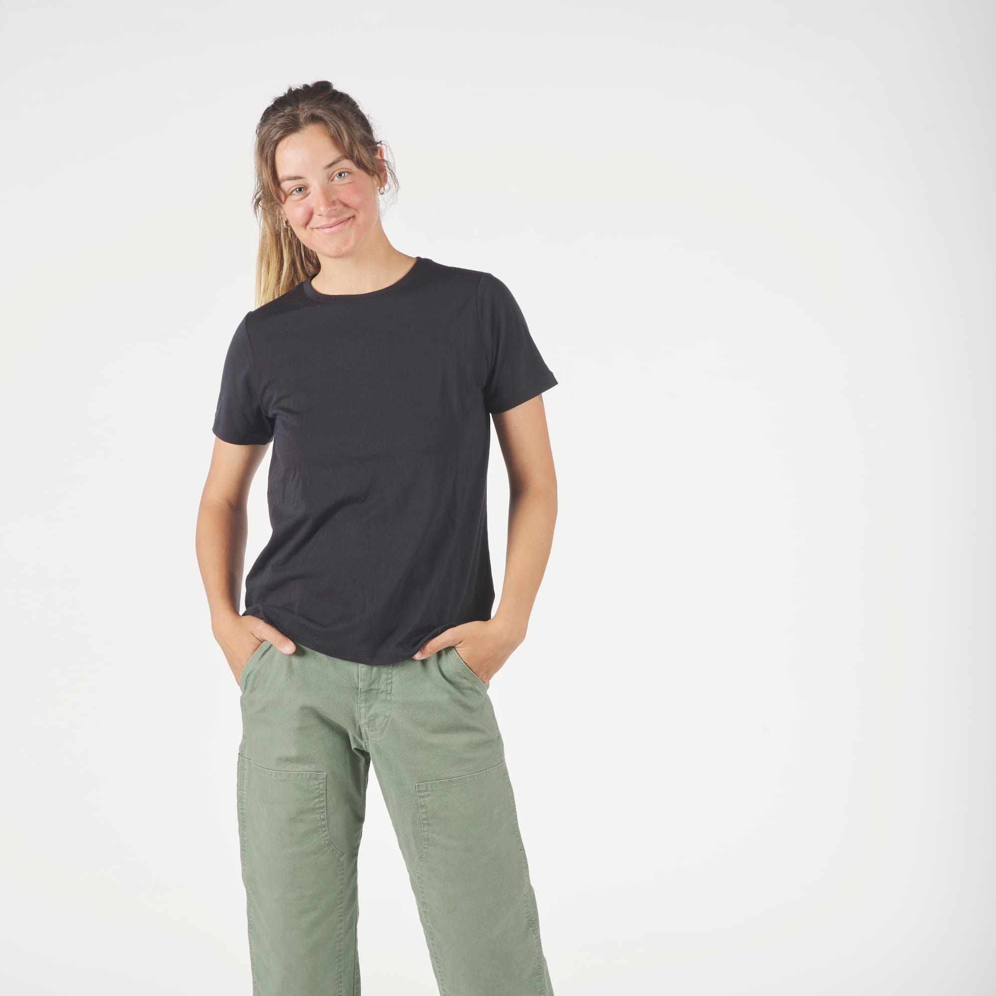 a woman wearing a black Journey Crew Merino Wool T-Shirt with green cargo pants