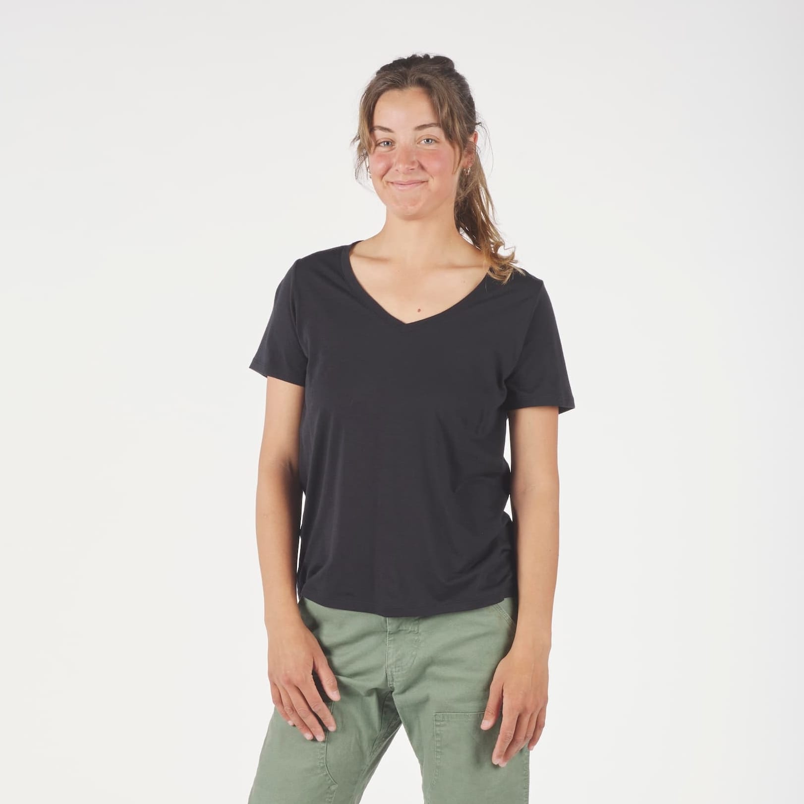 a woman wearing a Journey Merino Wool V-Neck T-Shirt in black with green cargo pants