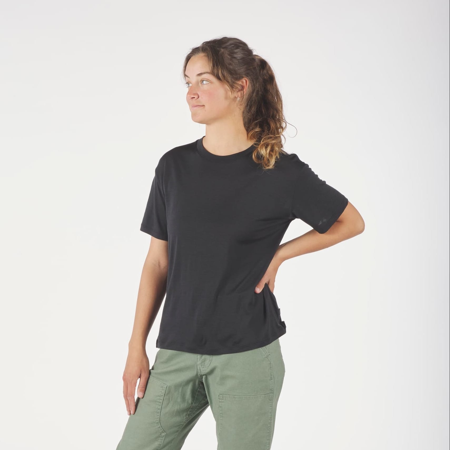 a woman wearing a black Canopy Merino Tencel T-Shirt with green cargo pants