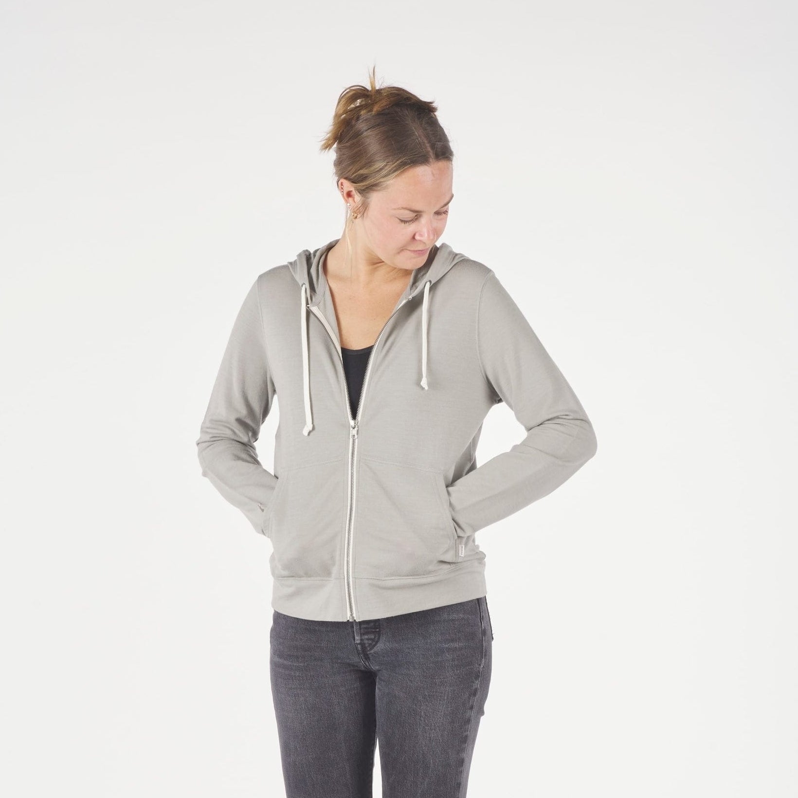 a woman wearing a Ridge Merino Traveler Hoodie in Rock Ridge