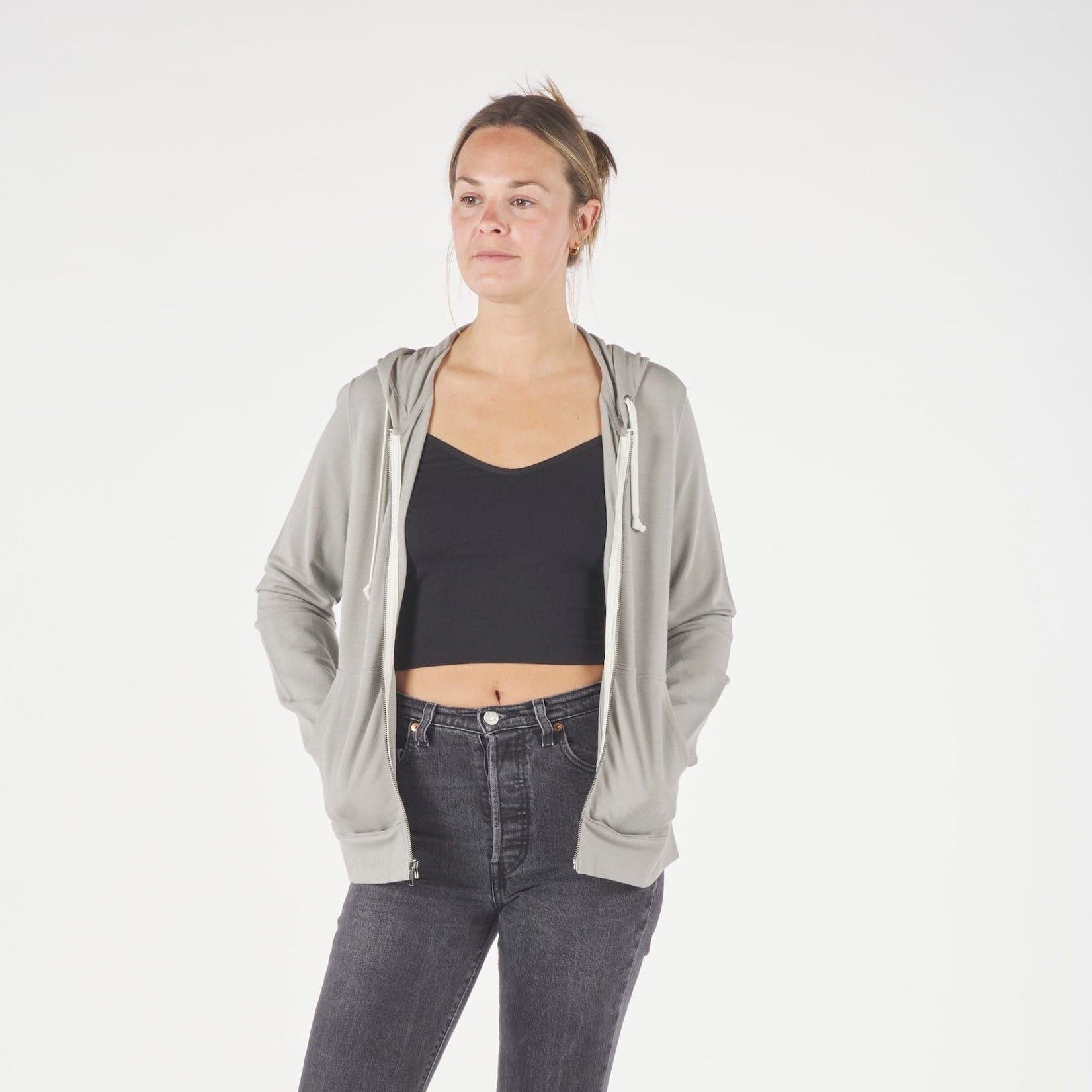 A woman wearing a Rock Ridge Traveler Hoodie over a black Ridge Merino Bralette