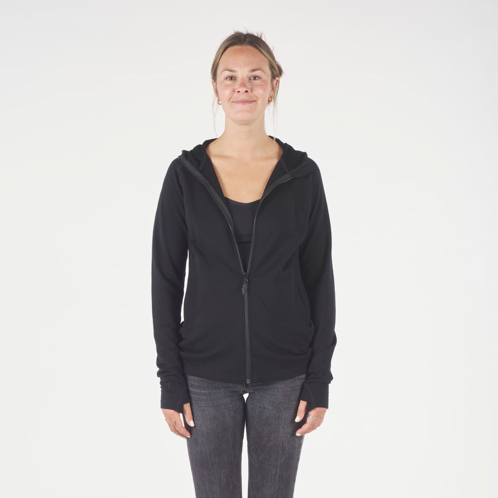 a woman wearing a black Hyde 100% Merino Hoodie with jeans