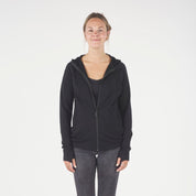 a woman wearing a black Hyde 100% Merino Hoodie with jeans