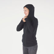 a woman zips up her black Hyde Hoodie