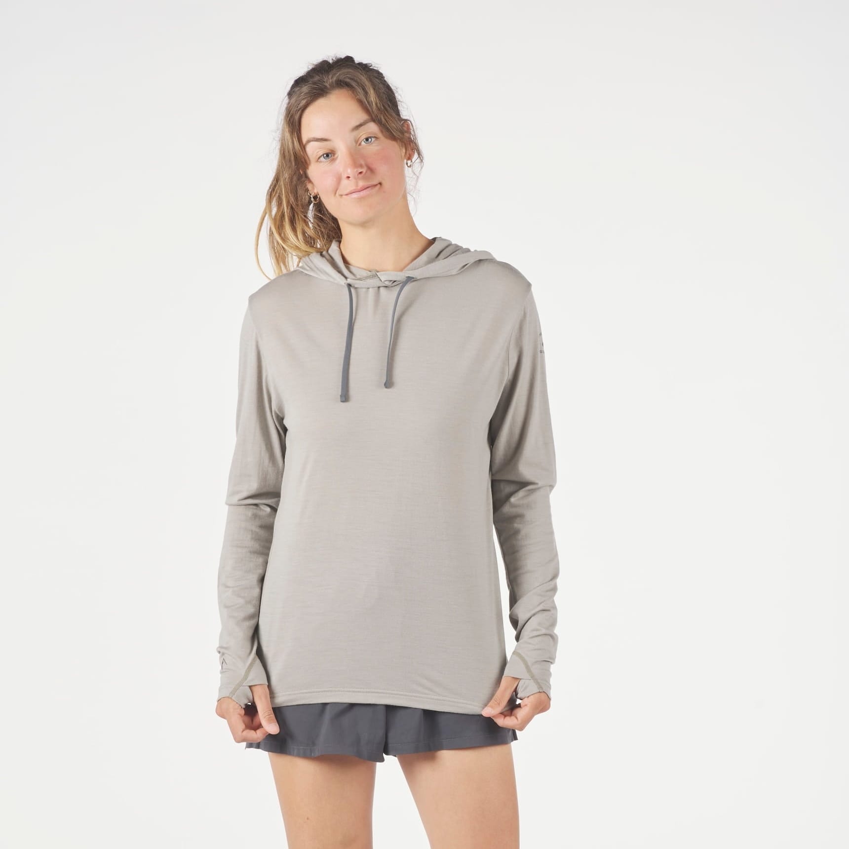 a runner wearing a Solstice Merino Wool Sun Hoodie in Rock Ridge