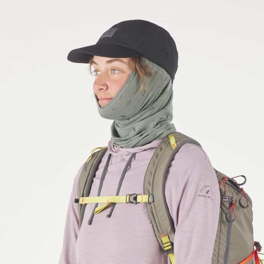 a woman wearing a Sierra Neck Tube in the backpacker print with a Ridge Run Hat and a Dusty Lilac Solstice Sun Hoodie