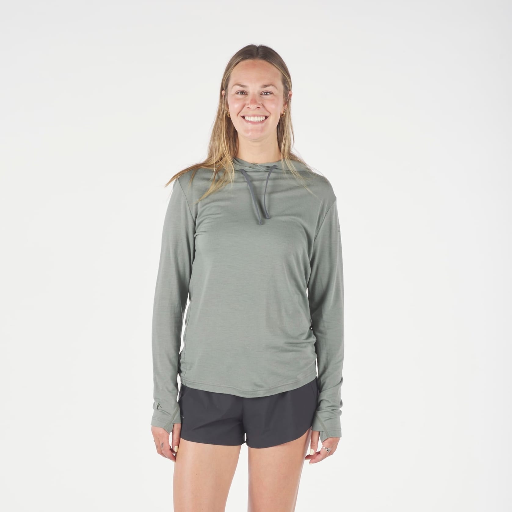 a runner wearing a Solstice Merino Sun Hoodie in Agave Green