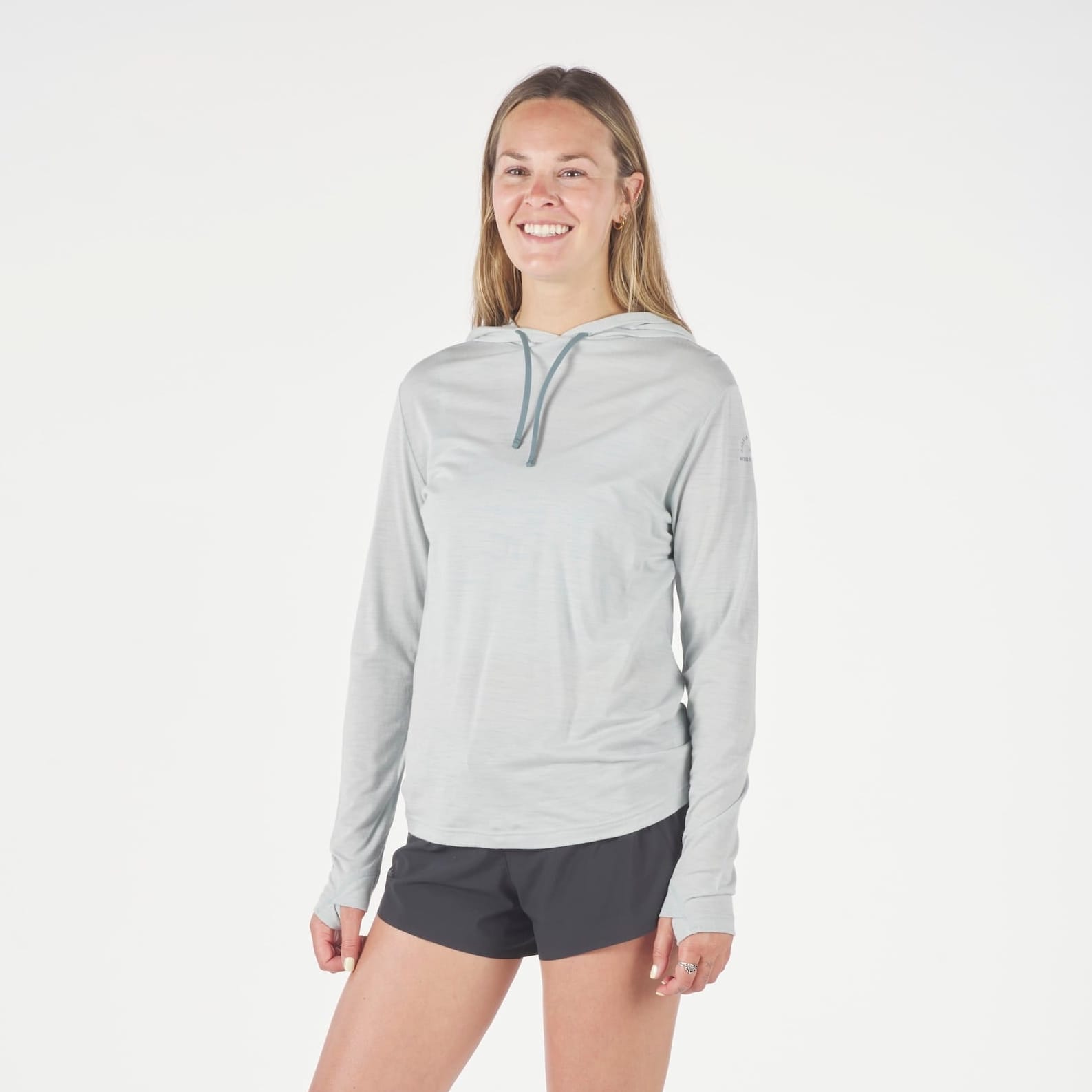 a woman wearing a Solstice Merino Sun Hoodie in Ice Flow