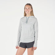 a woman wearing a Solstice Merino Sun Hoodie in Ice Flow