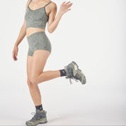a woman wearing Ridge Merino wool boy shorts in backpacker print with a matching bralette and hiking boots