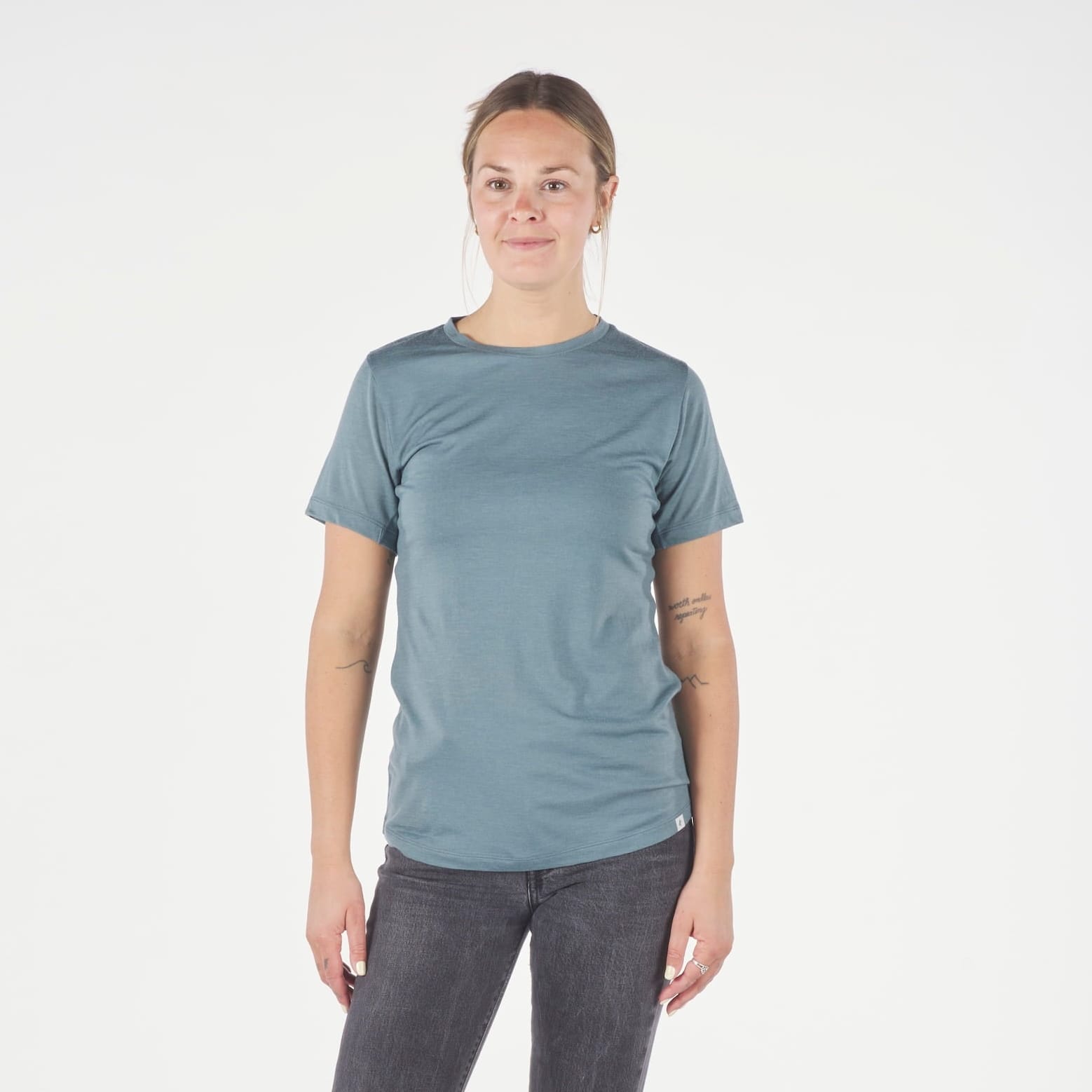a woman wearing a blue Pursuit T-Shirt with black jeans