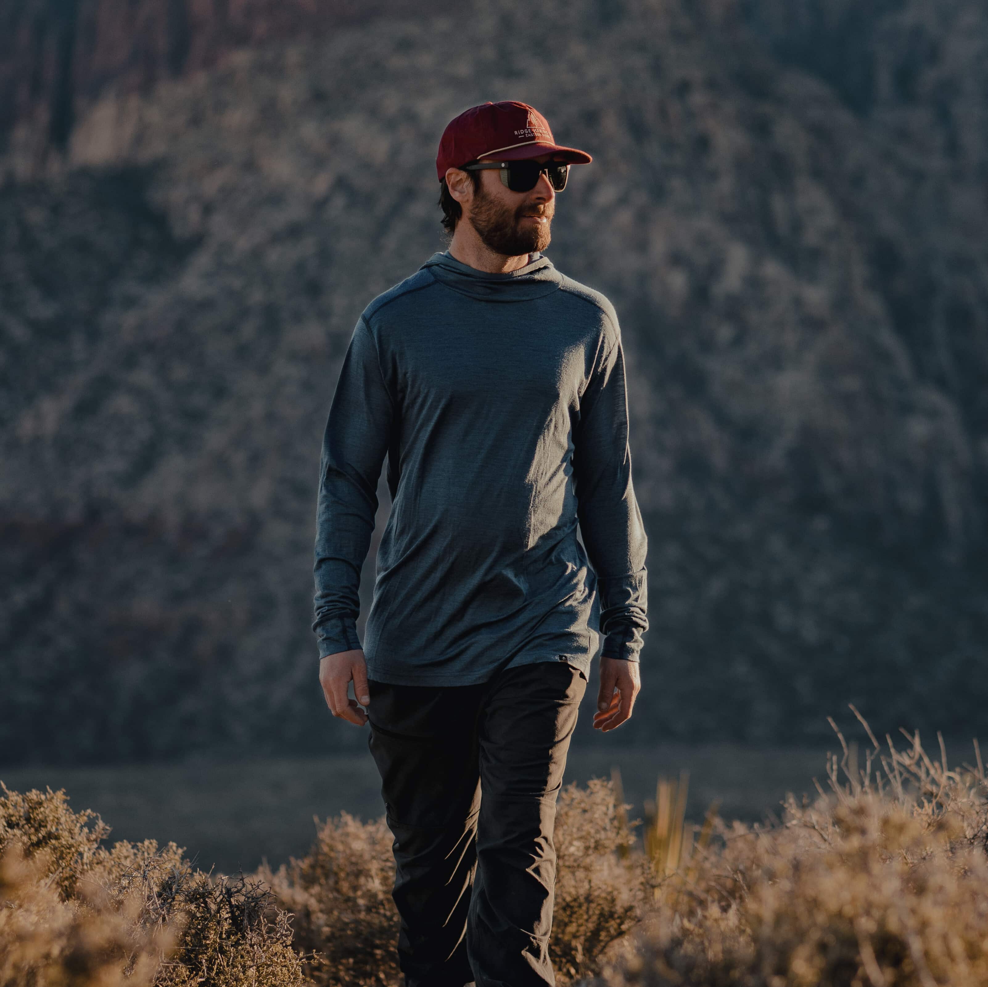 a man hiking in a Pursuit Ultralight Merino Hoodie