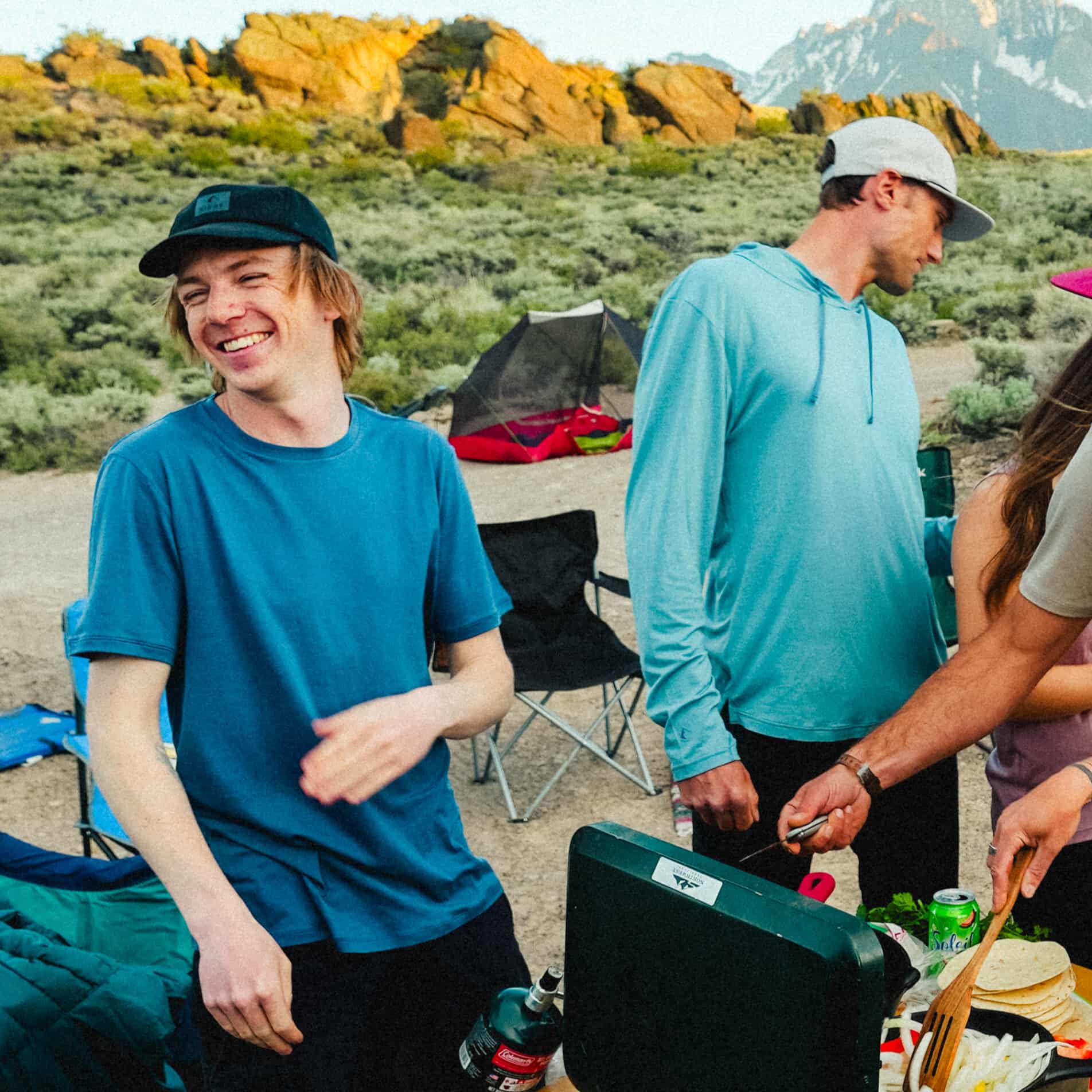 a man wearing a Journey Tee in Vintage Indigo grilling with friends