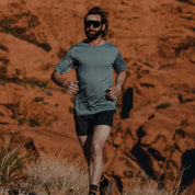 a man running in a Pursuit ultralight Merino tee in Smoke Blue