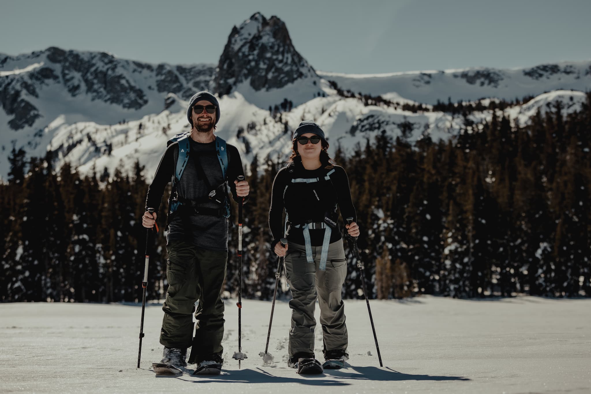 two skiers skinning in the Mammoth Lakes Basin beneath Crystal Crag