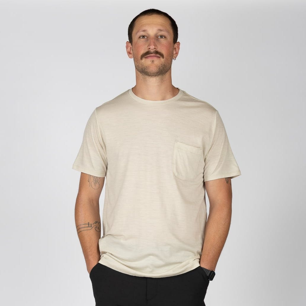a man wearing a Journey Merino Pocket Tee in Sand with black hiking pants