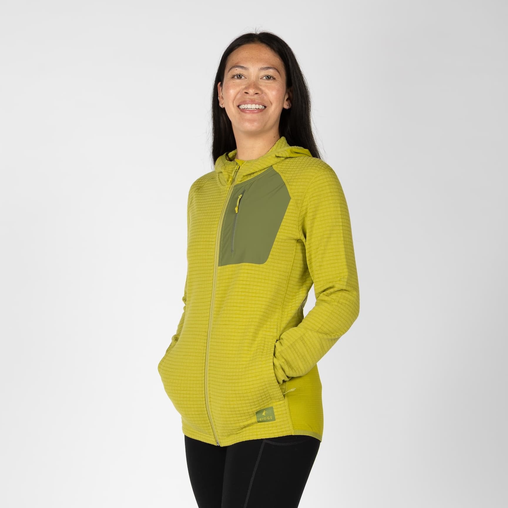 a woman wearing a Cloudripper Grid Fleece Full Zip in Golden Lime