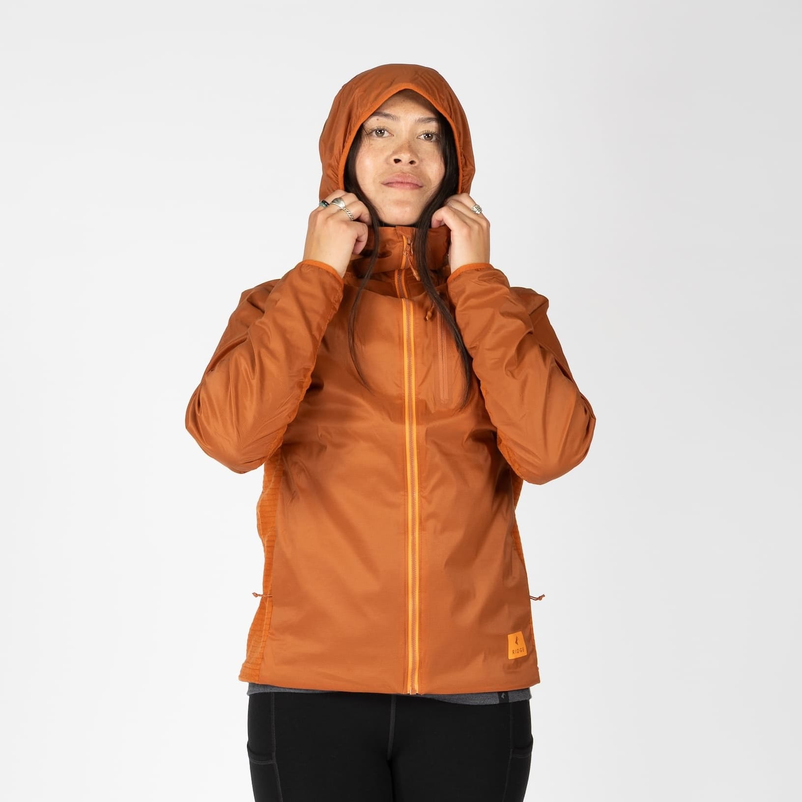 a woman wearing an orange Alpha Wool Insulated jacket
