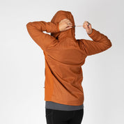 a woman showing the hood cinch on an orange Alpha Wool Insulated jacket