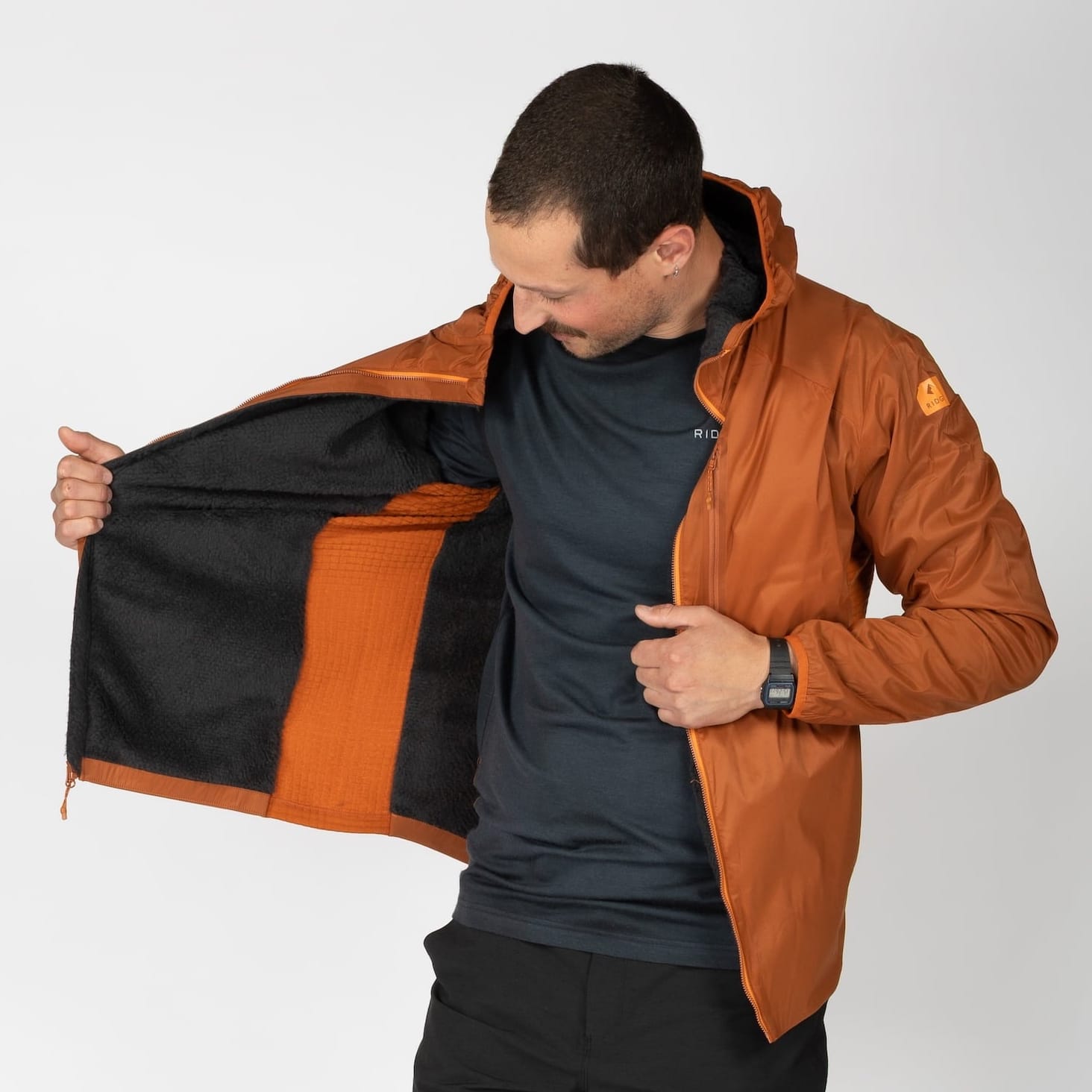 a man wearing an orange Alpha Wool Insulated Jacket with a Merino base layer underneath