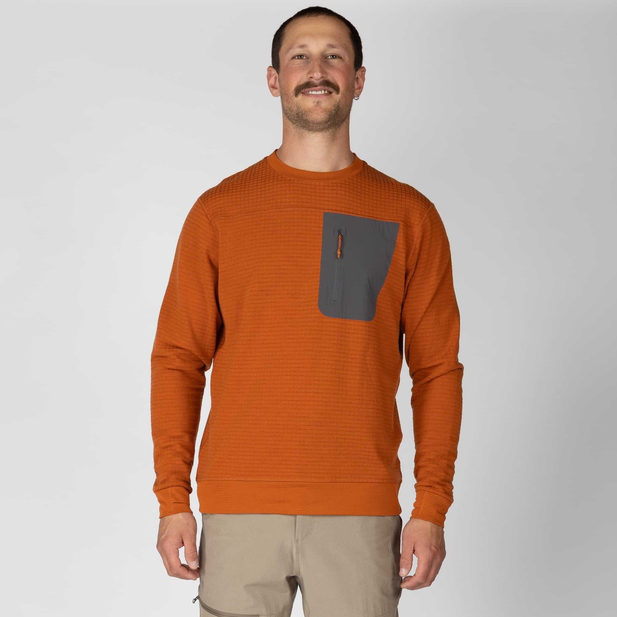 a man wearing a Cinnamon Cloudripper Crew Pullover with tan hiking pants