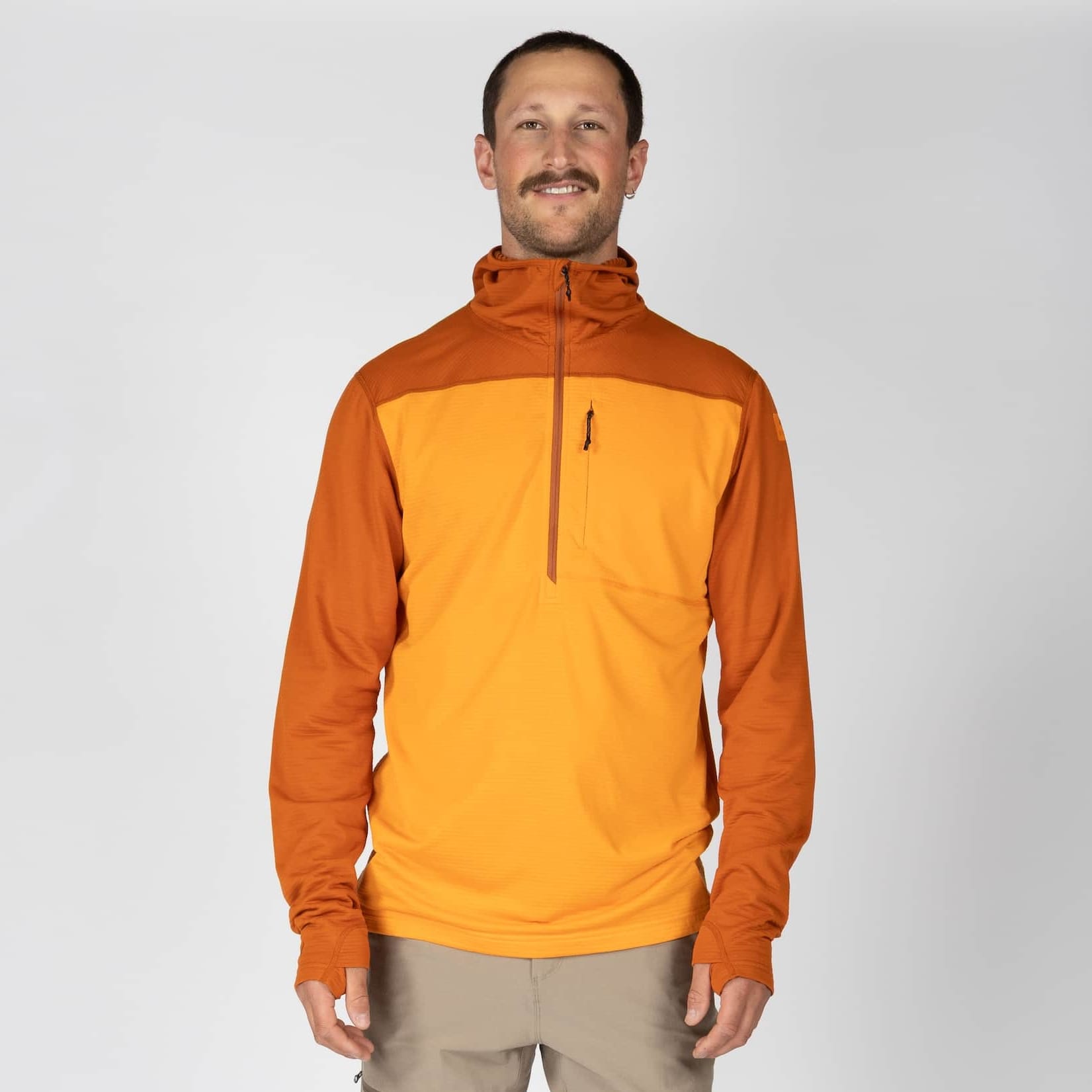 a man wearing a Convict Canyon Hoodie in orange with tan hiking pants