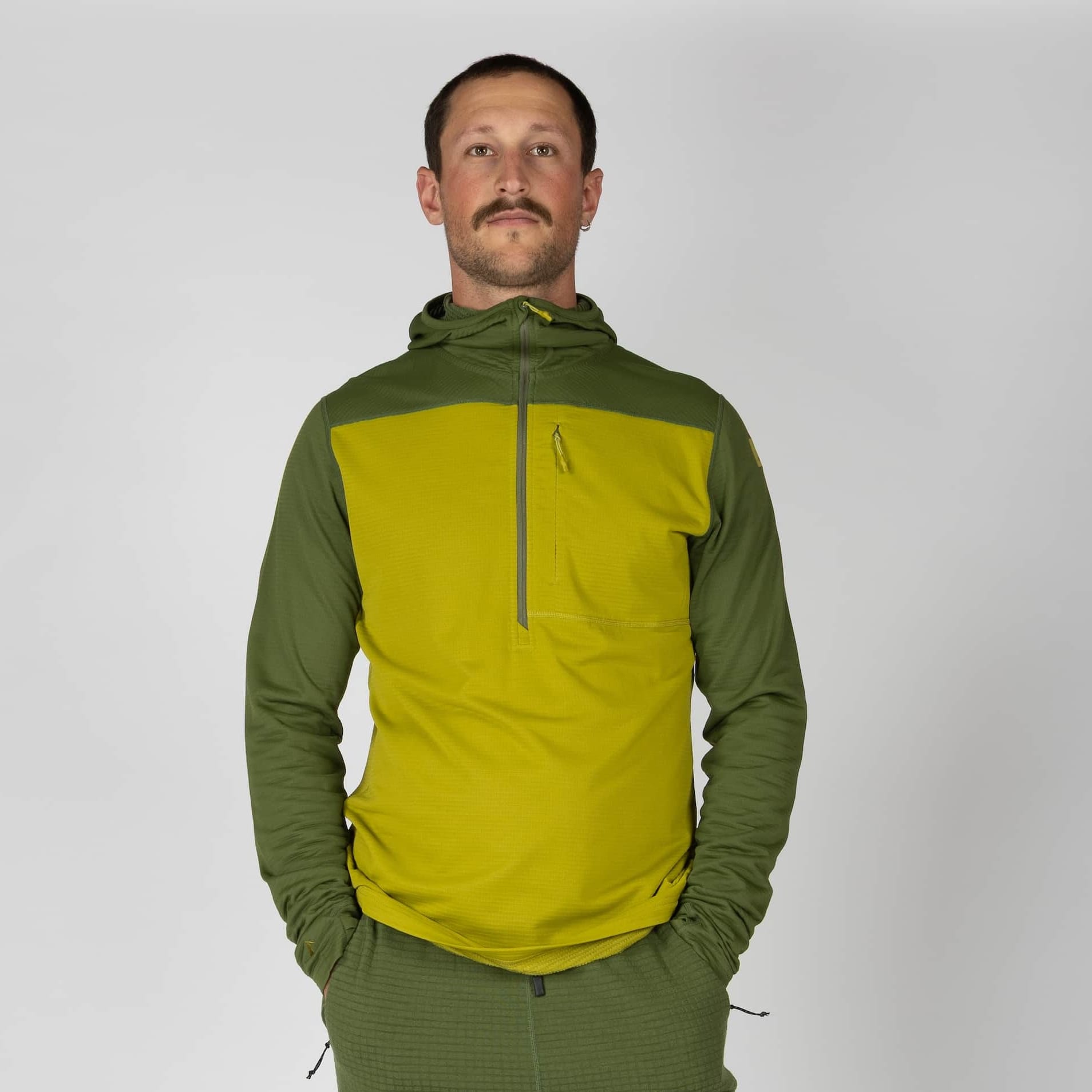a man wearing a green Convict Canyon Hoodie with Cloudripper Joggers