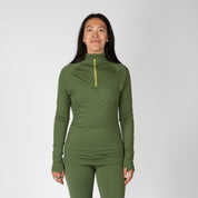 a woman wearing a 1/4 zip base layer top in Fern with matching bottoms