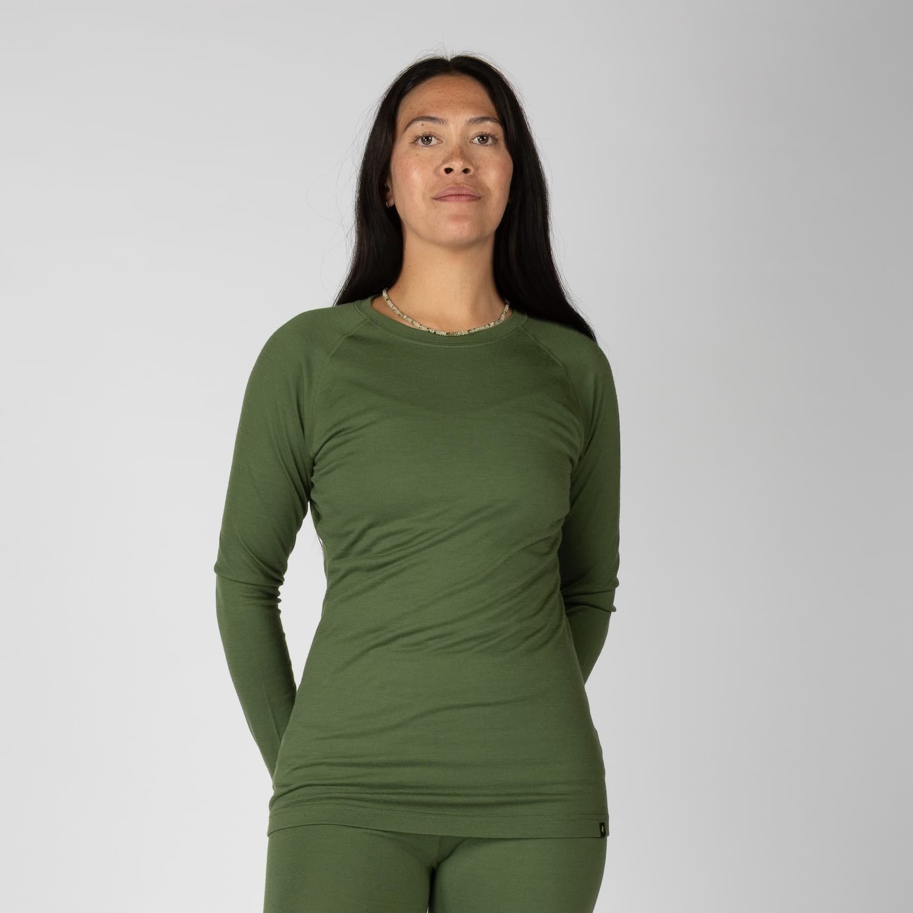 a woman wearing a Fern Aspect Base Layer Crew Top with matching bottoms