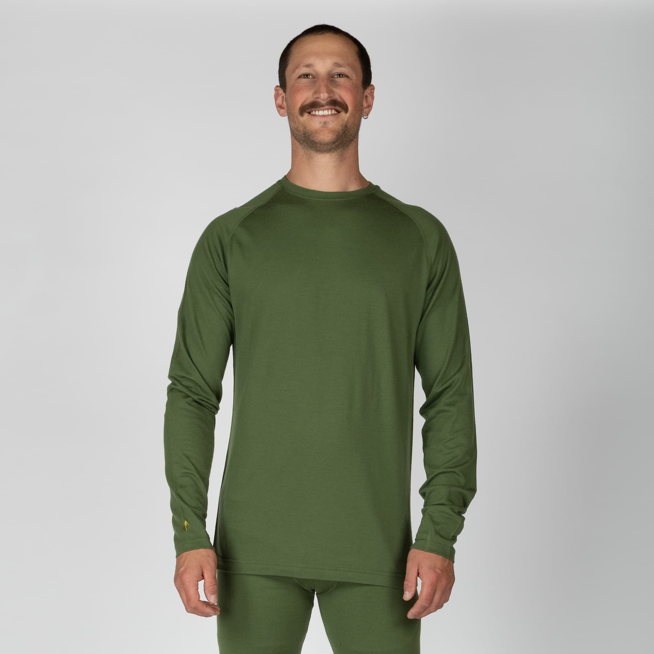 a man wearing an Aspect Base Layer Top in Fern