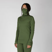a woman wearing an Aspect Merino High Neck Base Layer Top in Fern with matching bottoms
