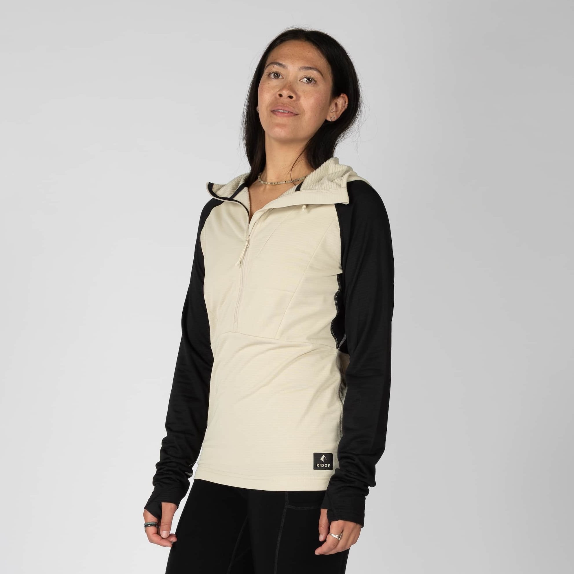 a woman wearing a Convict Canyon Hoodie in Sand/Black with black hiking pants