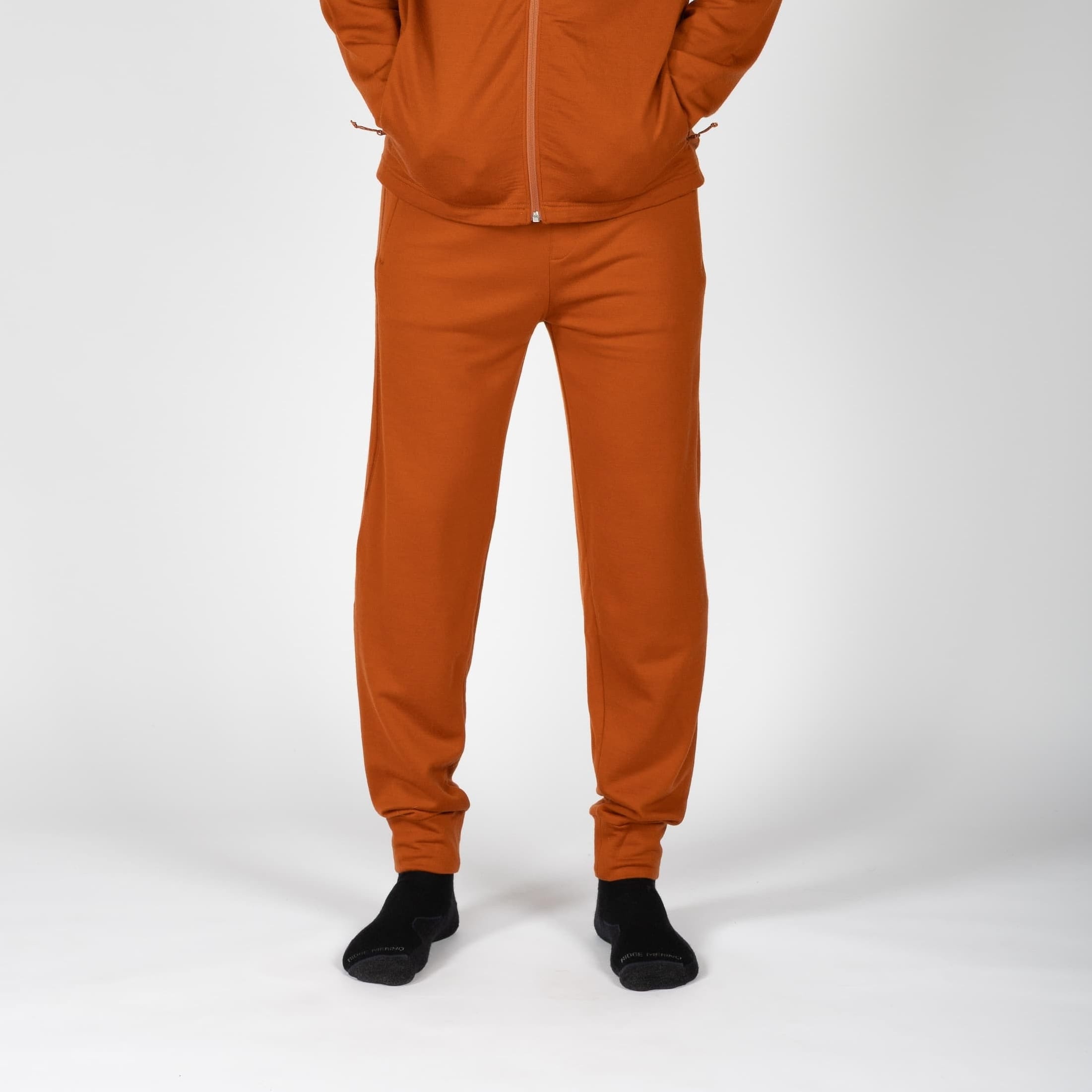 a man wearing Hyde 100% Merino wool joggers in orange with a matching hoodie