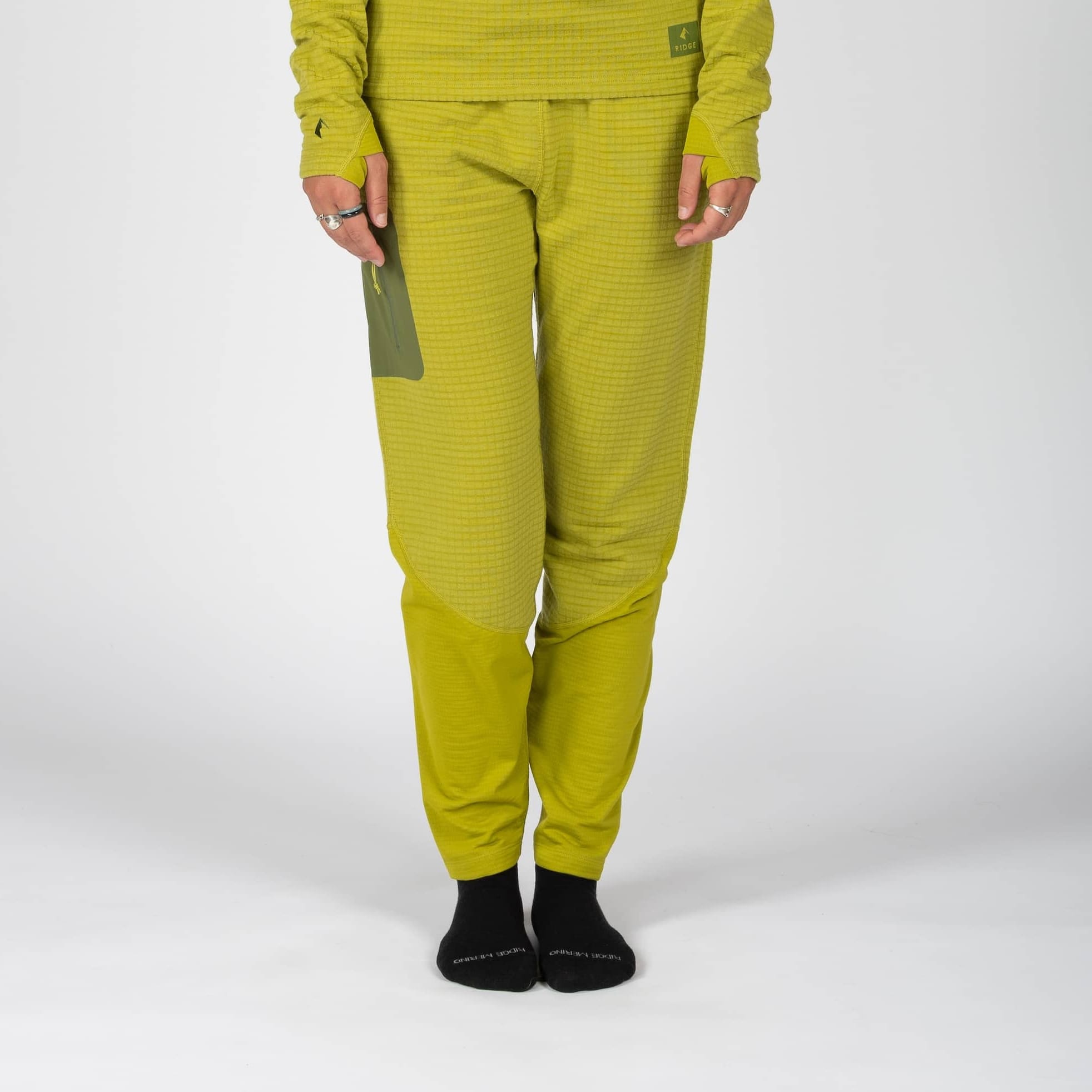 a woman wearing green Cloudripper Grid Fleece Pants