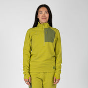 a woman wearing a Cloudripper Half Zip Pullover in Golden Lime with matching joggers