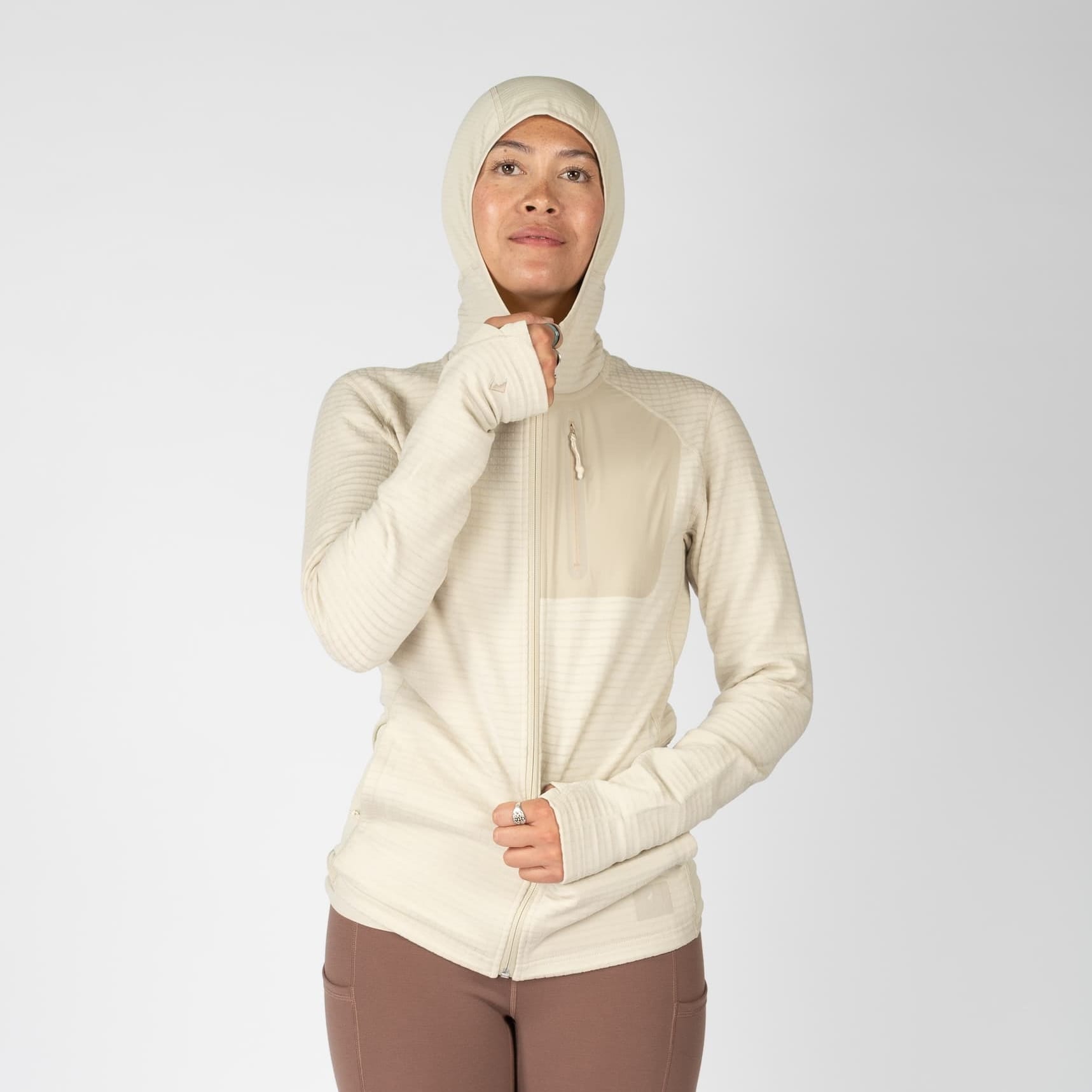 a woman zipping up a Cloudripper Full Zip Grid Fleece Jacket in Sand