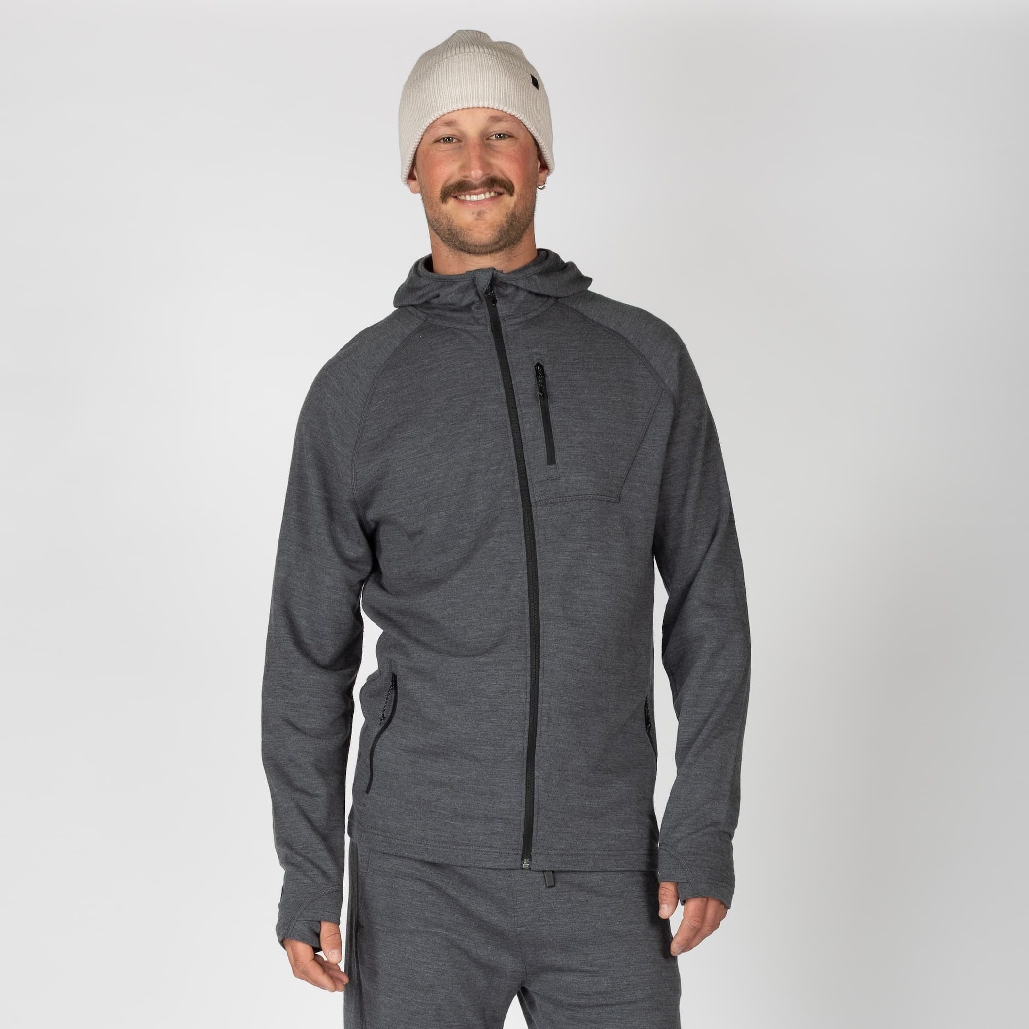 a man wearing a Charcoal Heather Hyde Hoodie with matching joggers and a Bone beanie