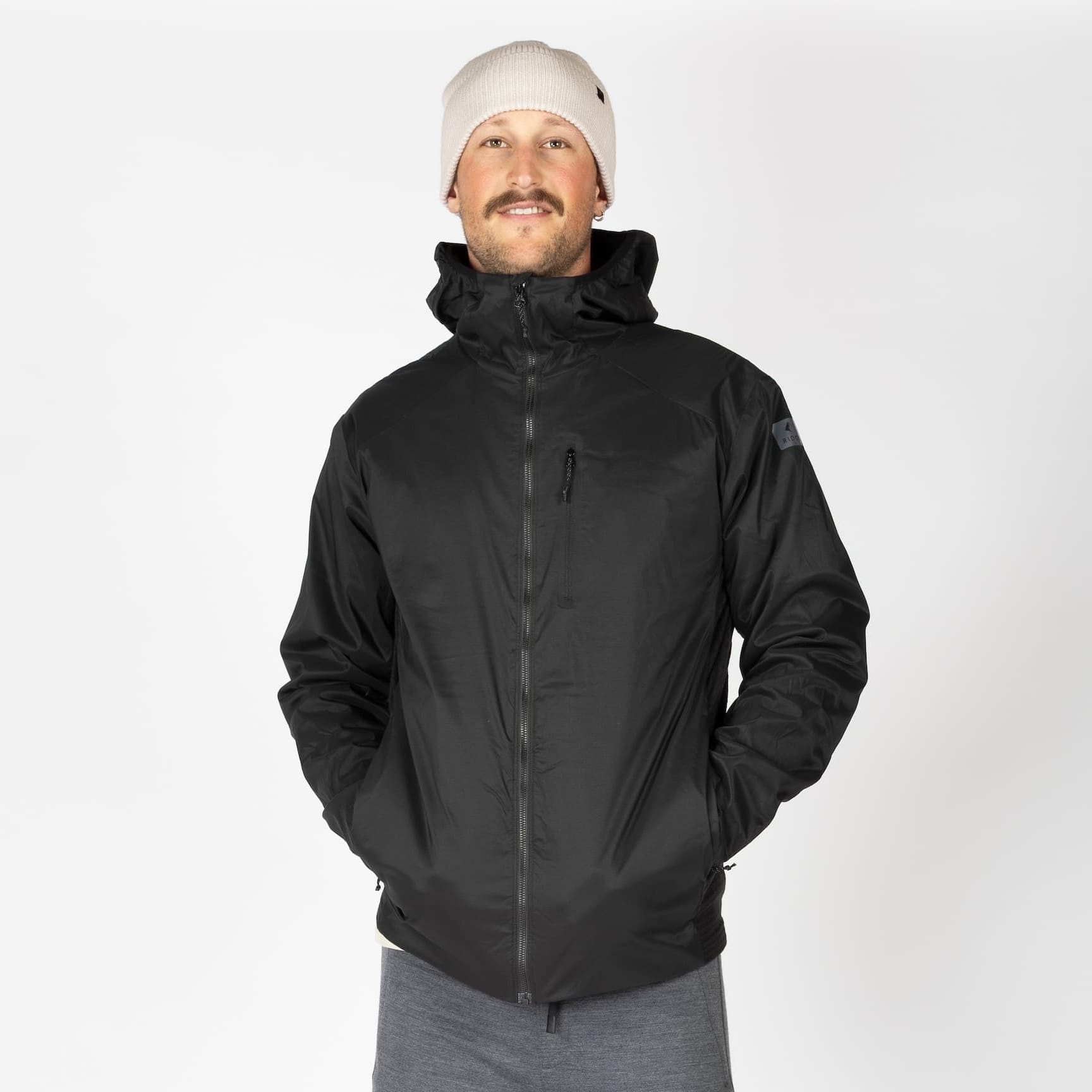 a man wearing a black Alpha Wool Insulated Jacket with a white beanie