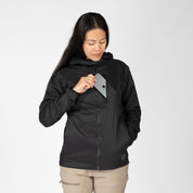 a woman putting a phone into the chest pocket of a black Alpha Wool Insulated Jacket