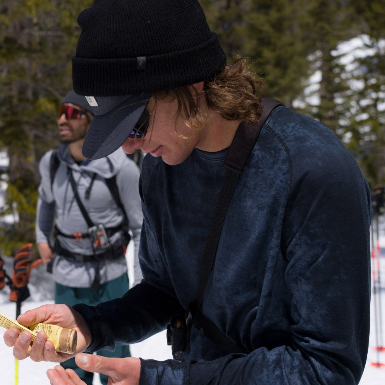a man puts on sunscreen wearing an Aspect base layer top