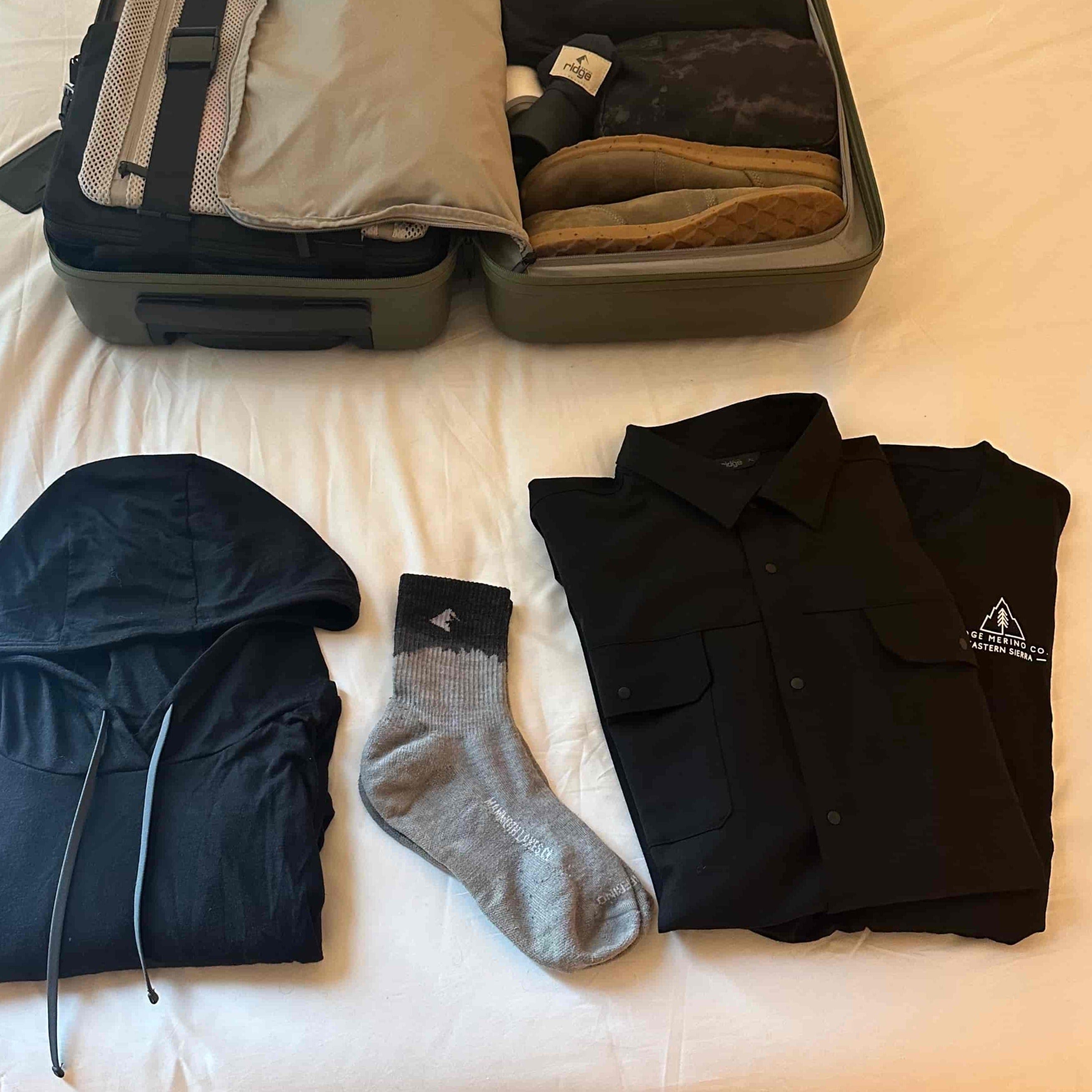 Minaret Socks laid out with a suitcase and other travel clothes