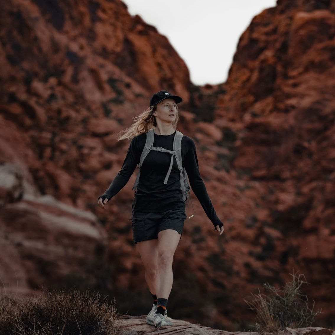 a woman hiking in a Ridge Merino Aspect Crew Long Sleeve Base Layer Shirt and shorts