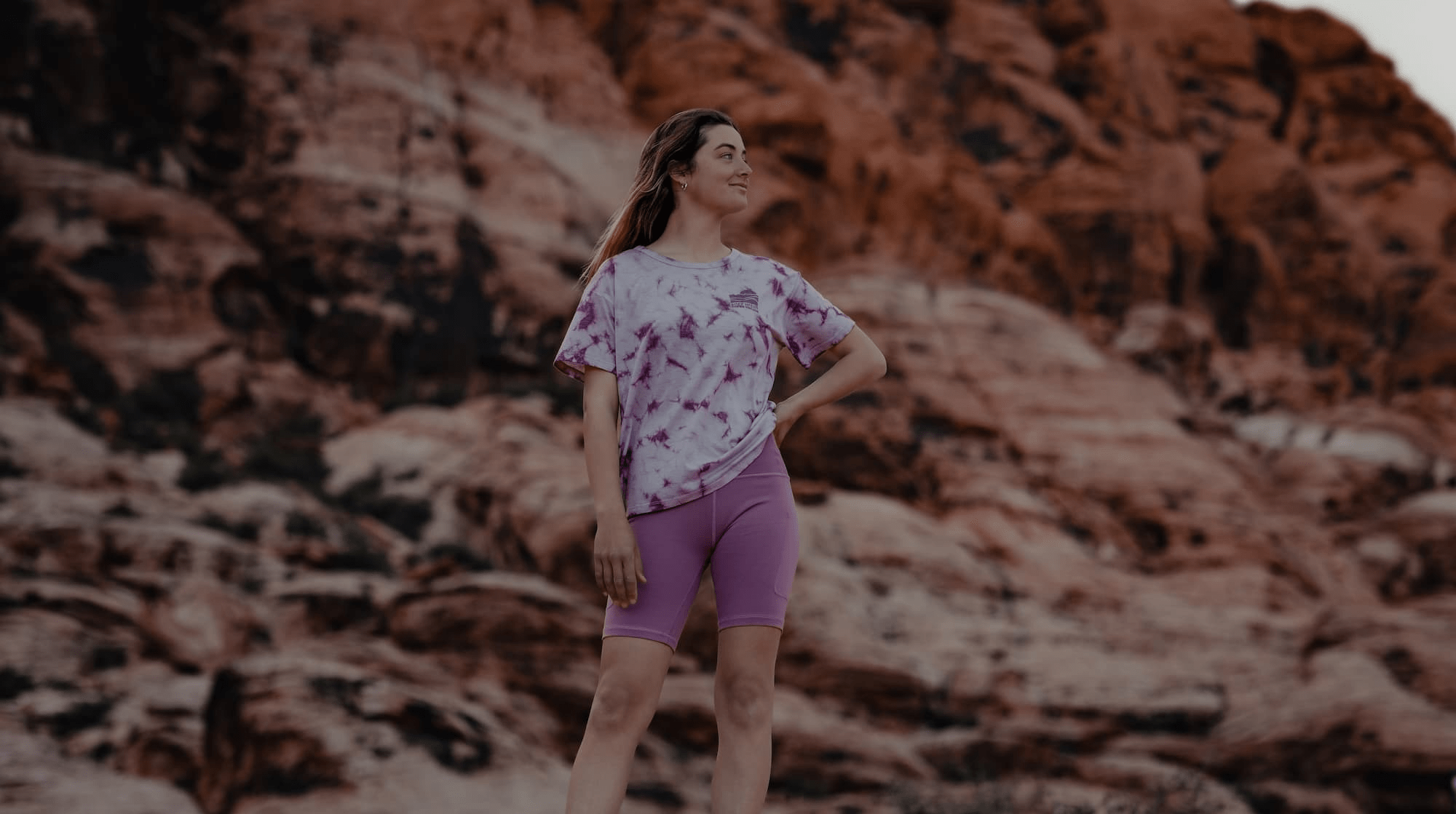 a hiker wearing a Ridge Merino tie-dye tshirt and Hilltop Bike Shorts in the desert