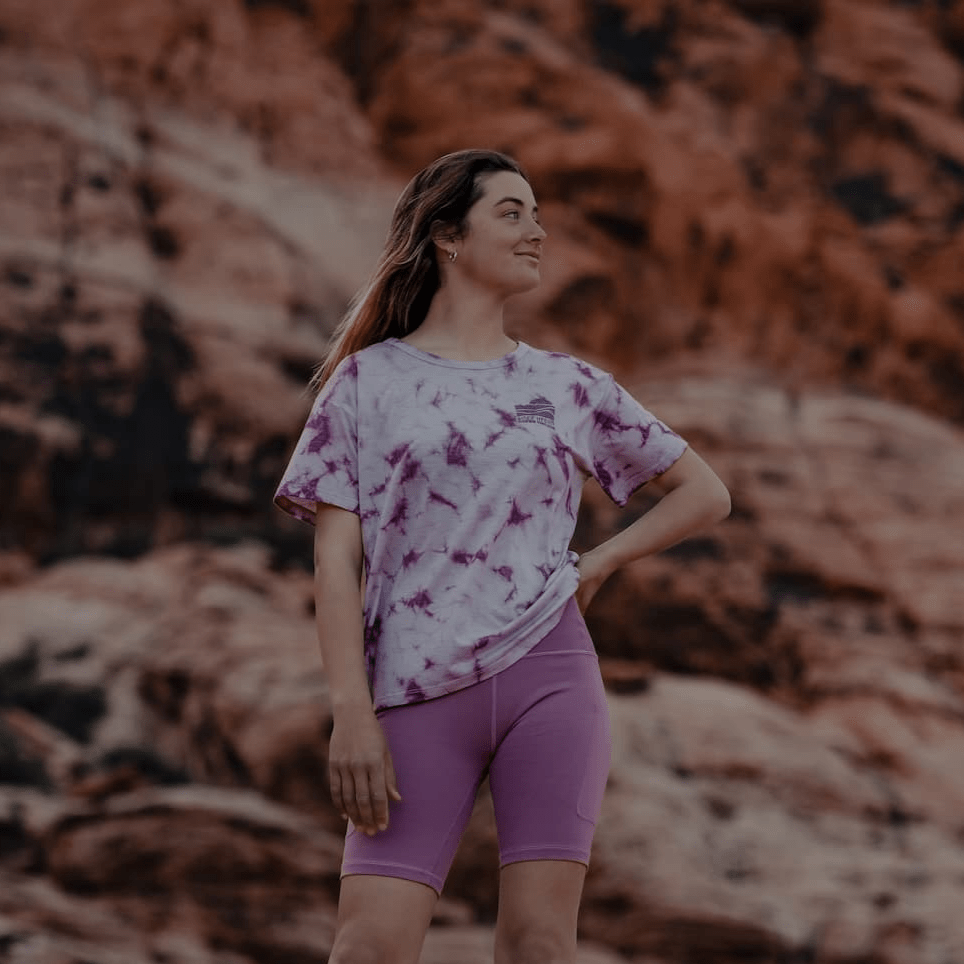 a hiker wearing a Ridge Merino tie-dye tshirt and Hilltop Bike Shorts in the desert