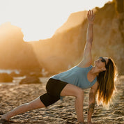 a woman does yoga on a beach in a Frankie Merino Wool Tank Top