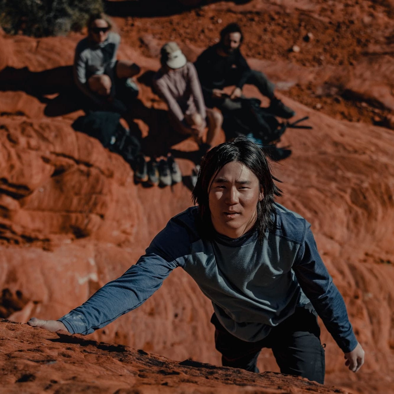 a man bouldering in a Pursuit Hoodie