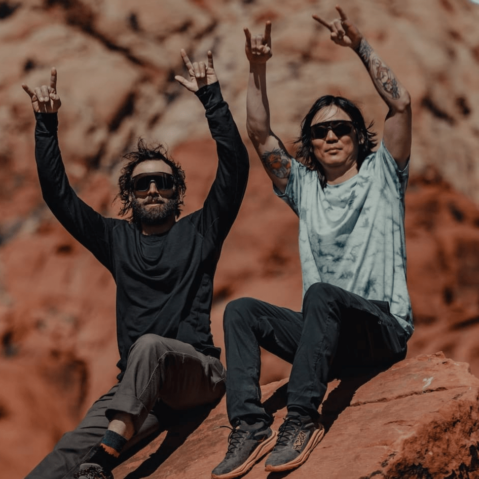 two friends, one wearing a Journey Tee in Tie-Dye and the other wearing a long sleeve Pursuit Shirt in black