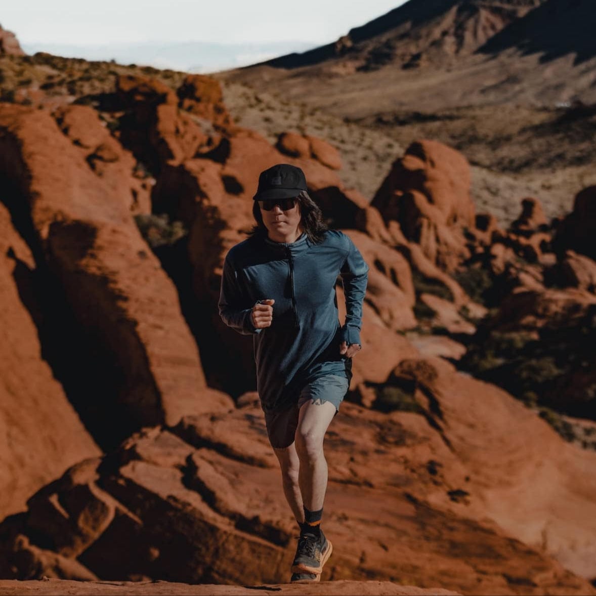 a man running in a Pursuit Pro Ultralight Merino Hoodie