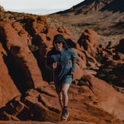 a man running in a Pursuit Pro Ultralight Merino Hoodie